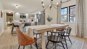 Een moderne keuken met een eethoek, een kroonluchter en uitzicht op de omgeving.