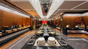A luxurious buffet area with a central walkway, elegant chandeliers, and neatly arranged food stations. - Shiji Jiamei Hotel (Suide)