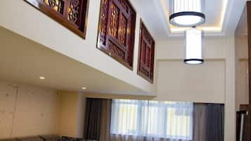 A modern living room with a sofa, decorative wall panels, and a ceiling light fixture.