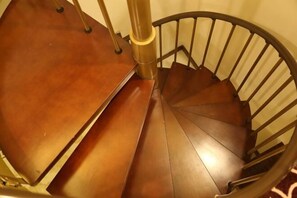 Una escalera de caracol con peldaños de madera y barandillas de metal.