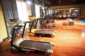 A gym with treadmills, stationary bikes, and weight machines. - Shiji Jiamei Hotel (Suide)