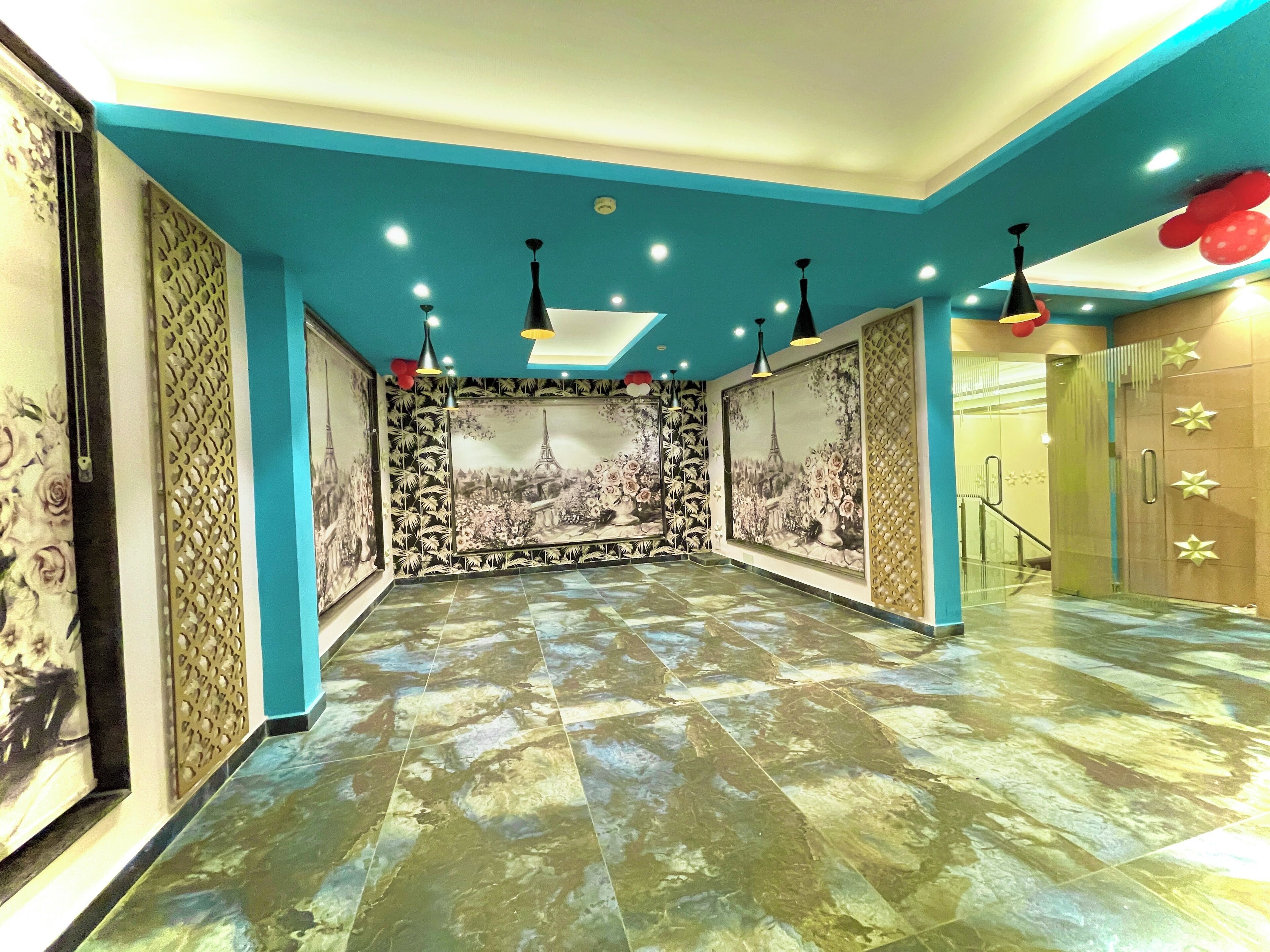 A hallway with a blue ceiling, patterned walls, and a tiled floor.