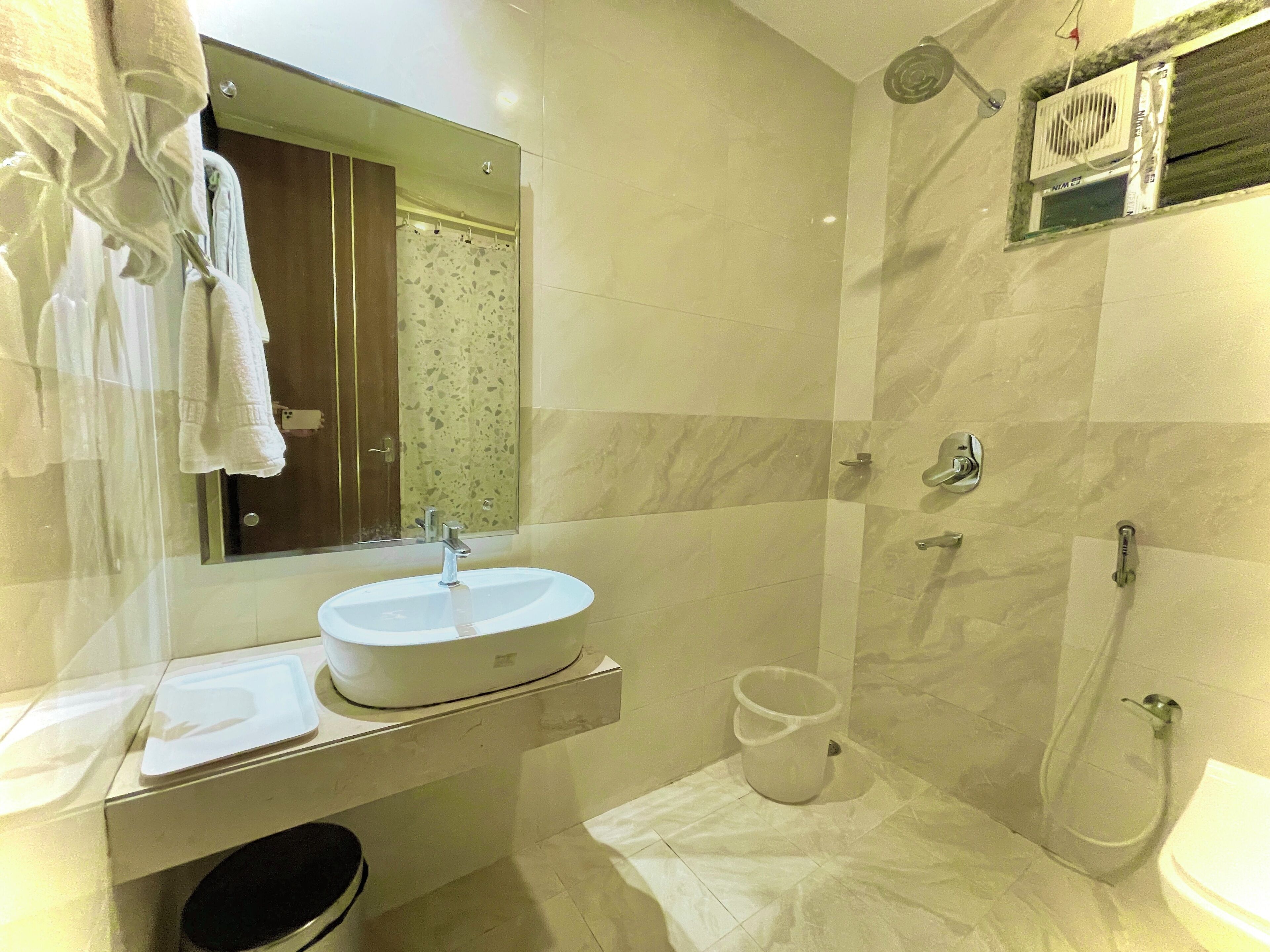 A bathroom with a sink, mirror, and shower.