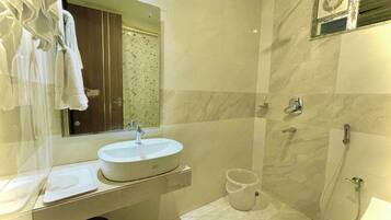 Un baño con lavamanos, espejo y ducha.