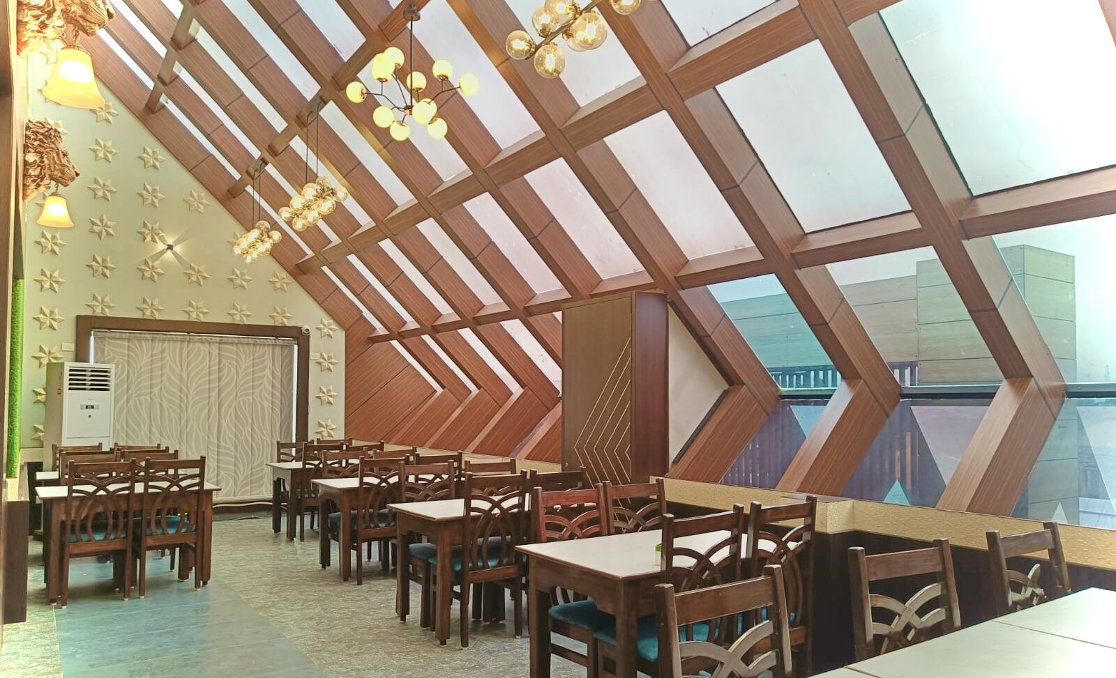 Un restaurante con techo alto y vigas de madera, con mesas y sillas dispuestas para comer.