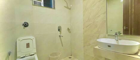 Une salle de bain comprenant des toilettes, un bidet, une douche et un lavabo.