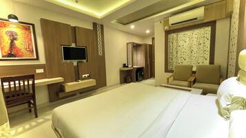 Habitación de hotel con una cama grande, televisión, escritorio y silla.