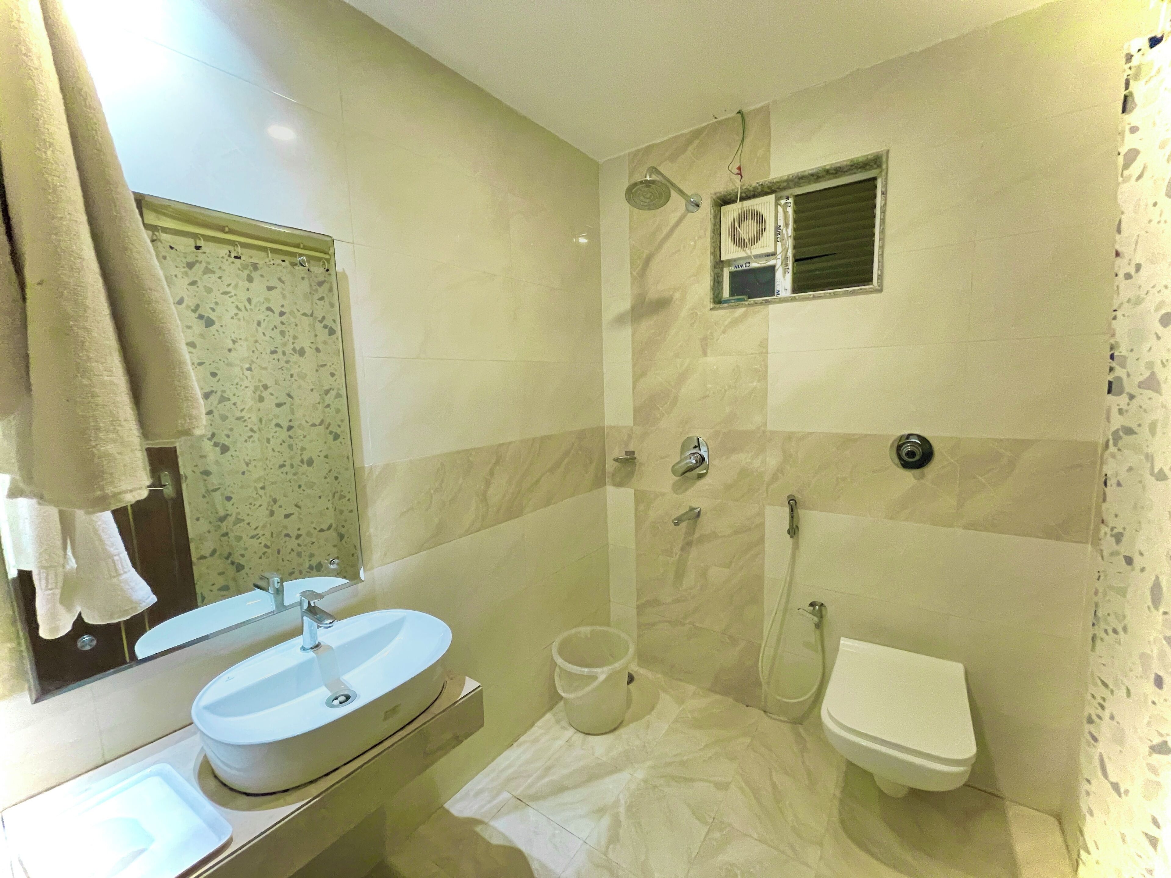 A bathroom with a sink, mirror, shower, and toilet.