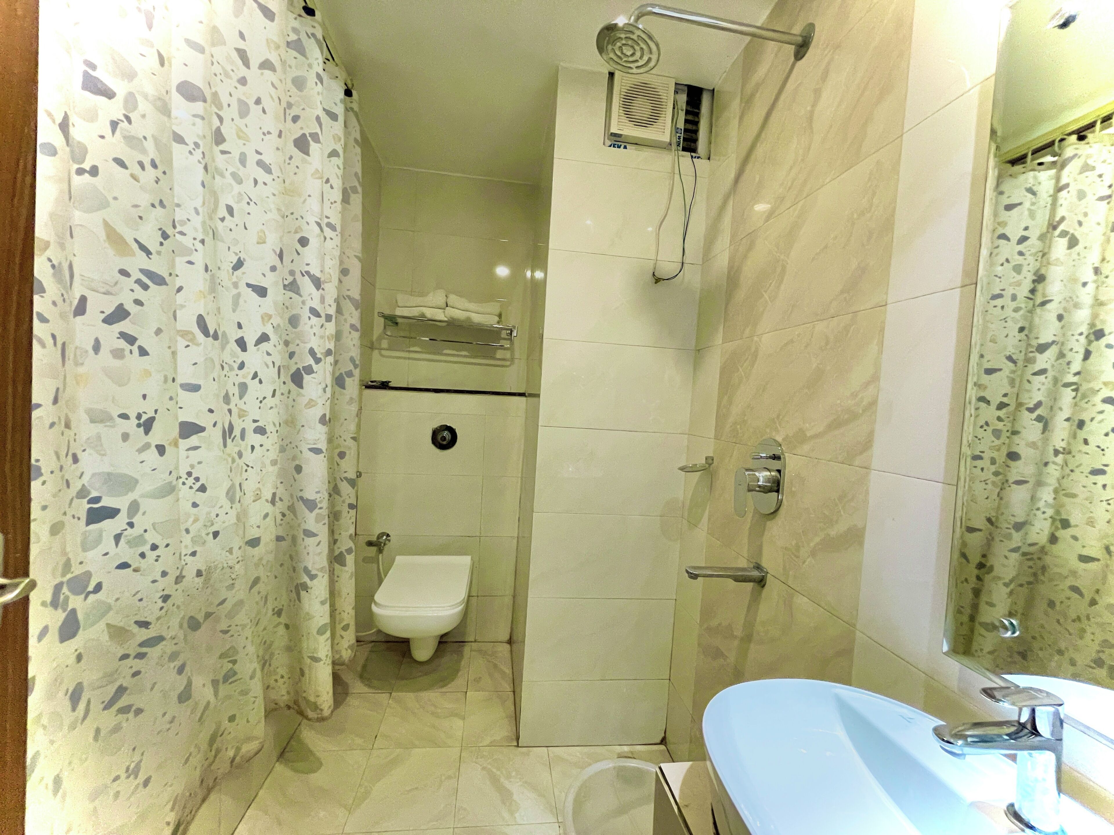 A bathroom with a shower, toilet, and sink.