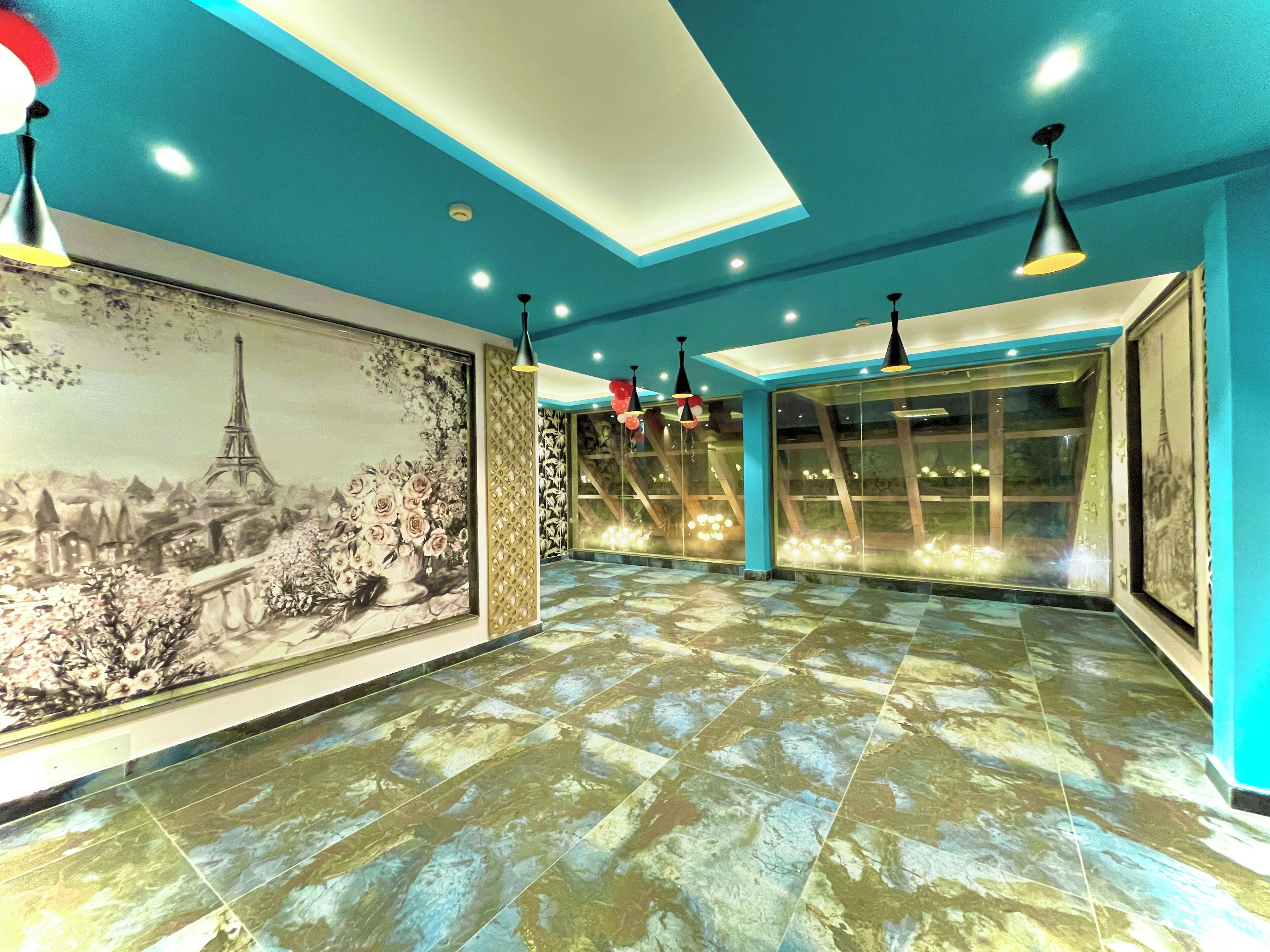 A spacious hallway with a tiled floor, large framed artwork depicting a cityscape, and modern pendant lighting.