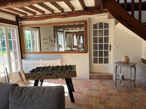 Relax in this charming room with a large mirror, foosball table, and decorative glass door.