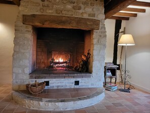 Cozy room features a traditional fireplace with a mantel, a wicker basket, and a floor lamp.