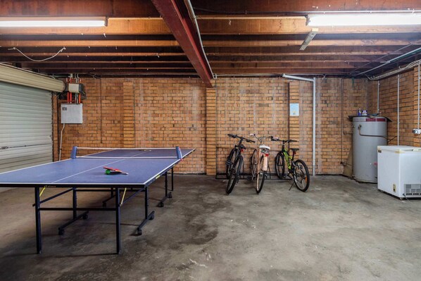 Un sous-sol équipé d’une table de ping-pong, de vélos et d’un chauffe-eau.