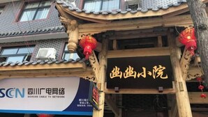 Un bâtiment traditionnel sur lequel on peut lire l’inscription : « Réseau de télévision par câble du Sichuan ».