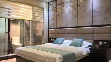 A modern bedroom with a large bed, a glass shower enclosure, and a decorative wall panel.
