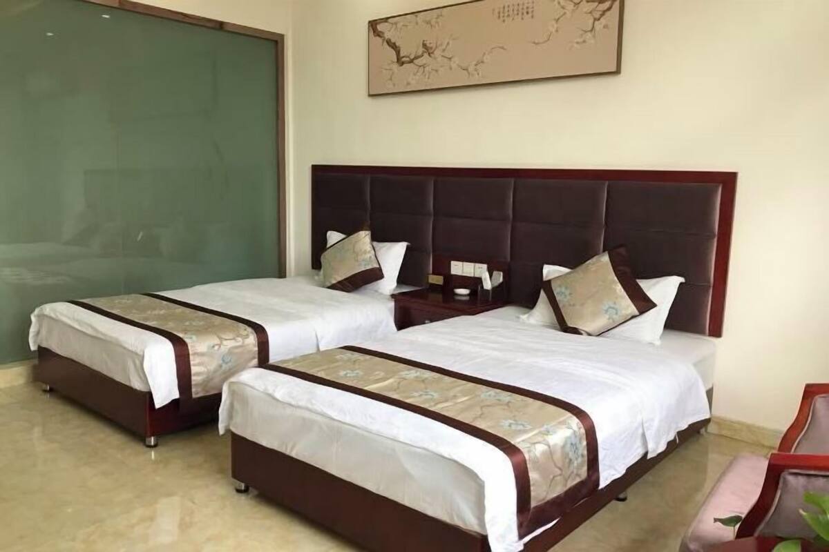 Une chambre d’hôtel avec deux lits, une grande fenêtre et une carte accrochée au mur.