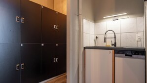 A modern kitchen with a built-in dishwasher and a black and white tiled backsplash. - MUE Cubes (Basel)