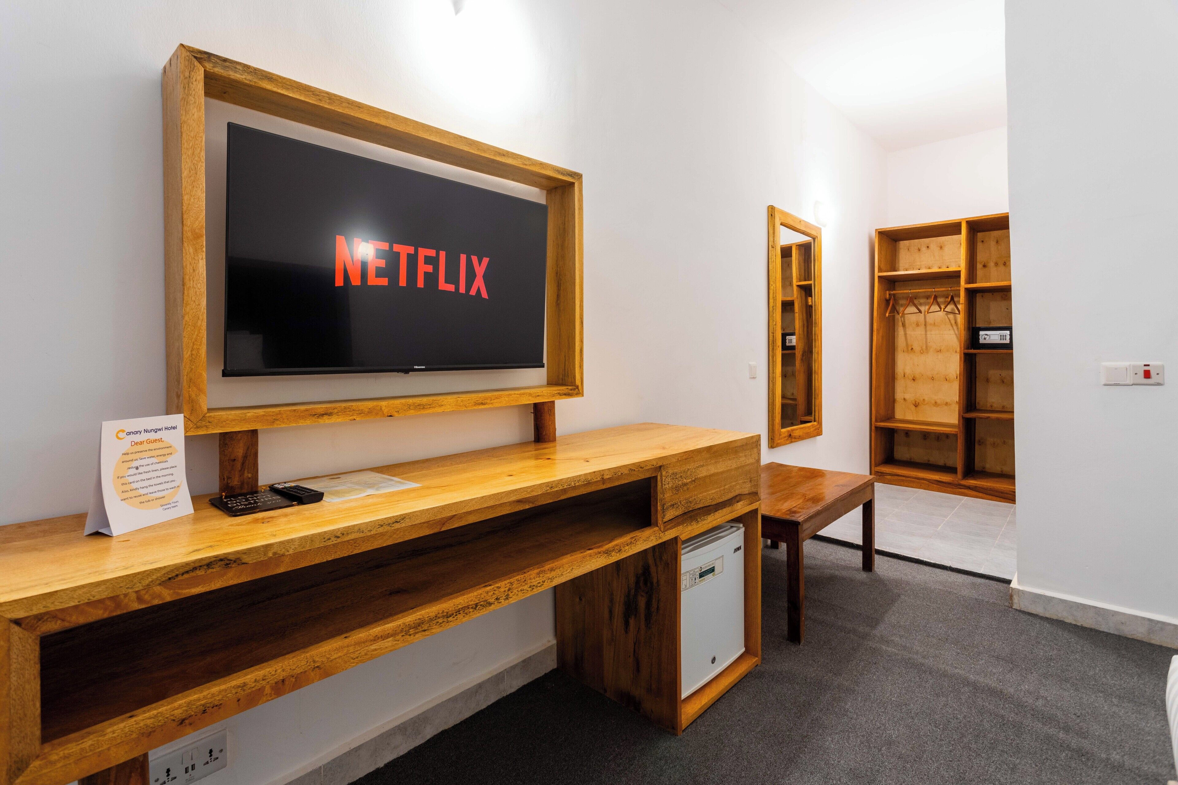 Ein Holzbüro mit einem Bildschirm, der 'NETFLIX' in roten Buchstaben anzeigt.