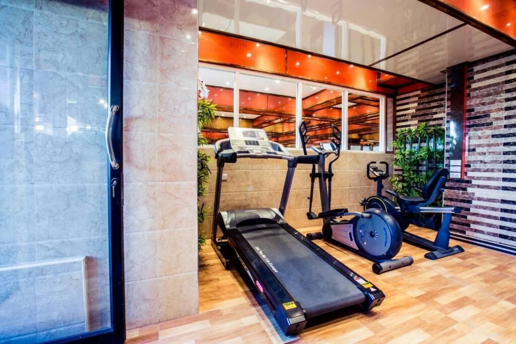 Un gimnasio moderno con cinta de correr, elíptica y bicicleta estática.