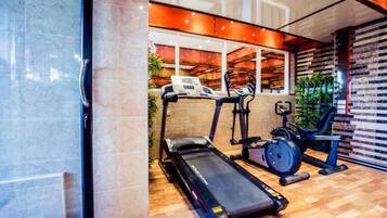 Un gimnasio moderno con cinta de correr, elíptica y bicicleta estática.