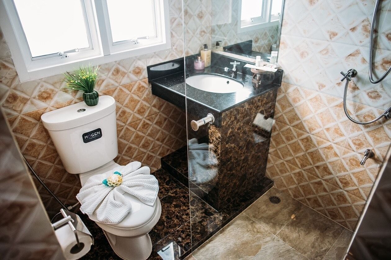 Un baño con inodoro, lavamanos y ducha.