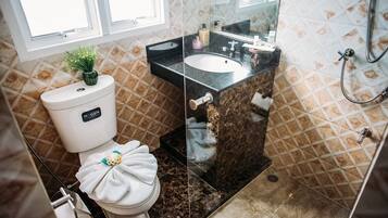 Un baño con inodoro, lavamanos y ducha.
