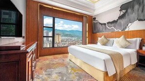 A hotel room with a large bed, a television, a view of a cityscape, and a painting on the wall. - Chongqing Yuhao Hotel (Chongqing)