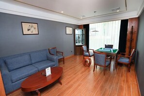 A room with a sofa, a coffee table, a desk with a computer, and a chair. - Chongqing Yuhao Hotel (Chongqing)