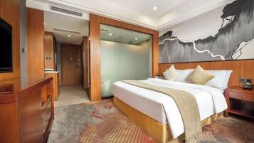 Habitación de hotel con una cama grande, un aparador de madera, un televisor y un cuadro en la pared.