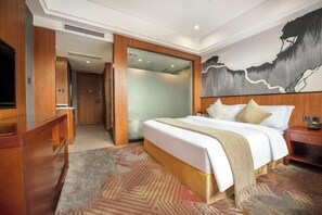 A hotel room with a large bed, a wooden dresser, a television, and a painting on the wall. - Chongqing Yuhao Hotel (Chongqing)