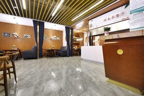 A hotel reception area with a wooden reception desk, seating area, and a clean, tiled floor. - Chongqing Yuhao Hotel (Chongqing)