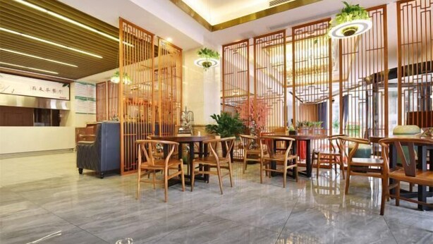 A modern restaurant interior with wooden furniture, a tiled floor, and a decorative partition. - Chongqing Yuhao Hotel (Chongqing)