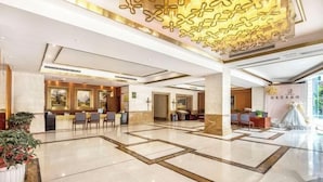 A spacious lobby with a reception desk, seating area, and decorative wall panels. - Chongqing Yuhao Hotel (Chongqing)
