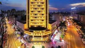 A multi-story hotel with a prominent entrance, surrounded by a cityscape at dusk. - Chongqing Yuhao Hotel (Chongqing)