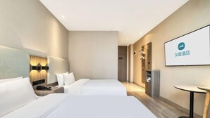 A hotel room with two beds, a desk, a chair, a TV, and a minibar. - Hanting Hotel (Hangzhou)