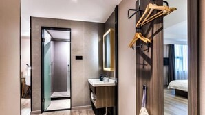 A modern hotel bathroom with a large mirror, wooden vanity, and a towel rack. - Hanting Hotel (Hangzhou)