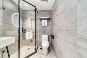 A modern bathroom with a glass shower enclosure, a white toilet, and a towel rack. - Hanting Hotel (Hangzhou)