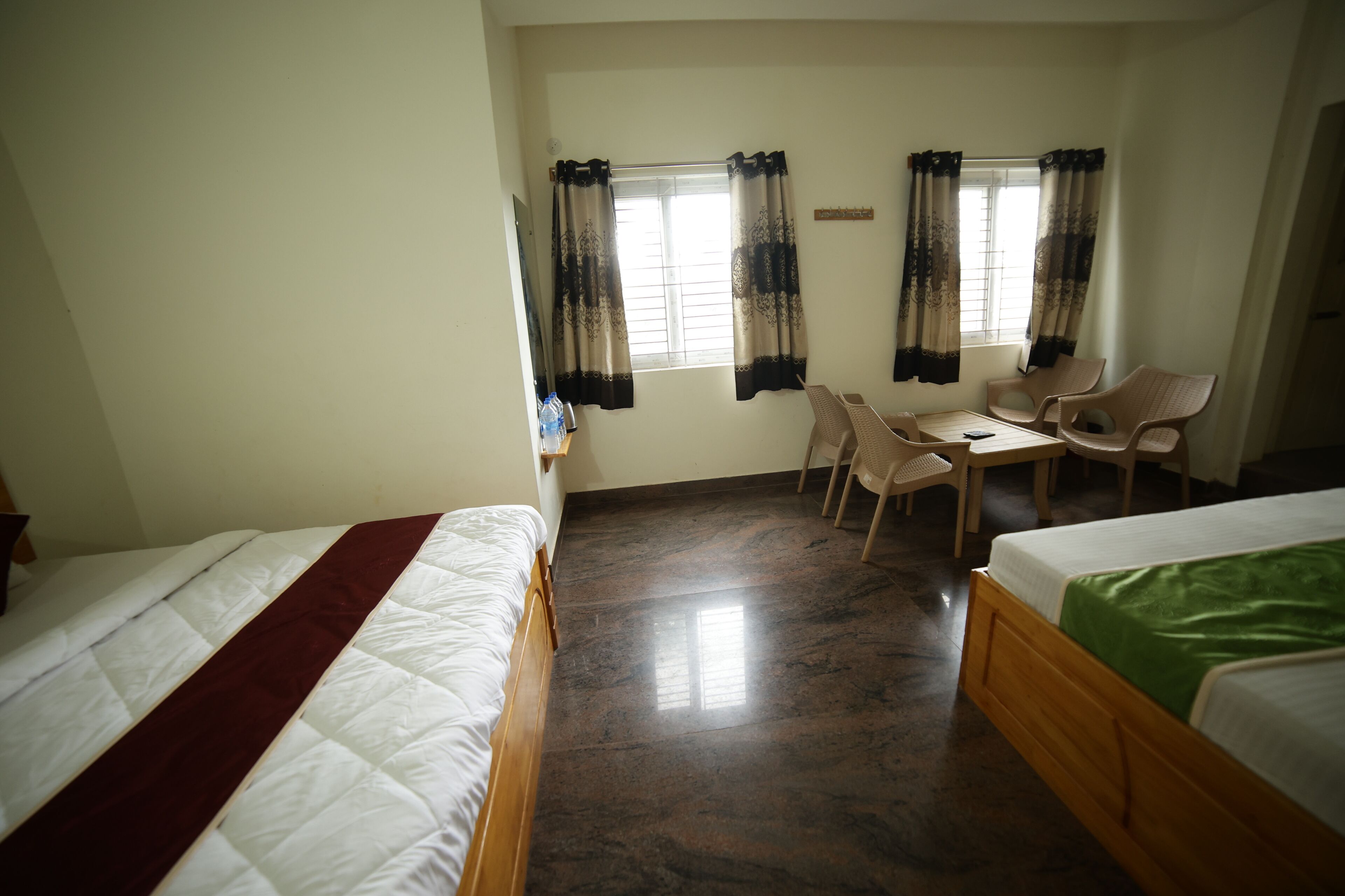 Ein Zimmer mit zwei Betten, einem Tisch und Stühlen.