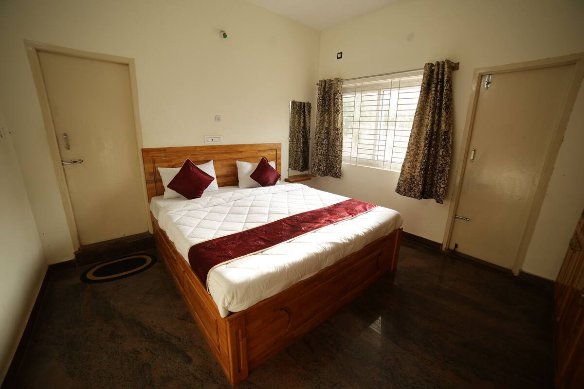 Ein Schlafzimmer mit einem hölzernen Bett, einem Fenster mit Vorhängen und einer Tür.