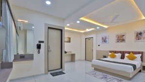 Una habitación de hotel moderna con una cama grande, un escritorio, un espejo y un baño.