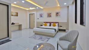 Un dormitorio moderno con una cama grande, mesitas de noche, una silla y obras de arte en las paredes.
