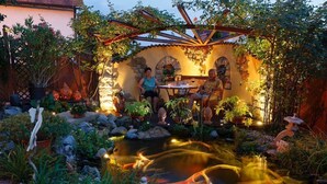 A garden with a pond, seating area, and stone structures. - Apartment 'Wassergartenparadies' with Shared Terrace, Shared Garden and Wi-Fi (Harsdorf)