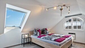 A bedroom with a skylight, a bed with patterned bedding, a small bedside table, and a decorative ceiling light. - Holiday Home 'Sonja' with Private Terrace, Wi-Fi and Air Conditioning (Lichtenwalde)