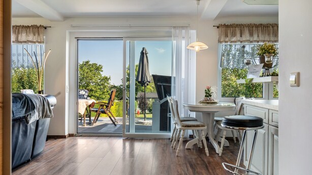 A modern kitchen with a dining area, large sliding glass doors, and a view of the outdoors. - Holiday Home 'Sonja' with Private Terrace, Wi-Fi and Air Conditioning (Lichtenwalde)