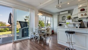 A modern kitchen with a dining area, large windows, and a view of the outdoors. - Holiday Home 'Sonja' with Private Terrace, Wi-Fi and Air Conditioning (Lichtenwalde)