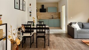 Un espacio habitable compacto con comedor, kitchenette y sofá.