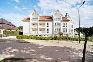 A large, white, two-story building with a red-tiled roof, multiple balconies, and a prominent tower. - Apartment 'Haus Baltic - Ferienwohnung 29' with Balcony and Wi-Fi (Sellin)
