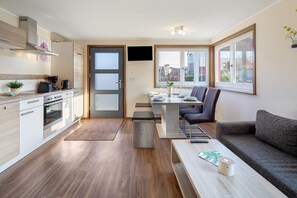 A modern kitchen with a dining area, a sofa, and a coffee table.