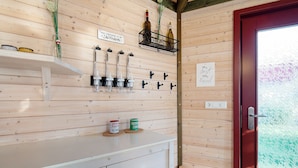 Ein Holzinterieur mit einer weißen Theke, Weinflaschen und einer roten Tür.