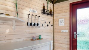 Interior de madera con mostrador blanco, botellas de vino y una puerta roja.